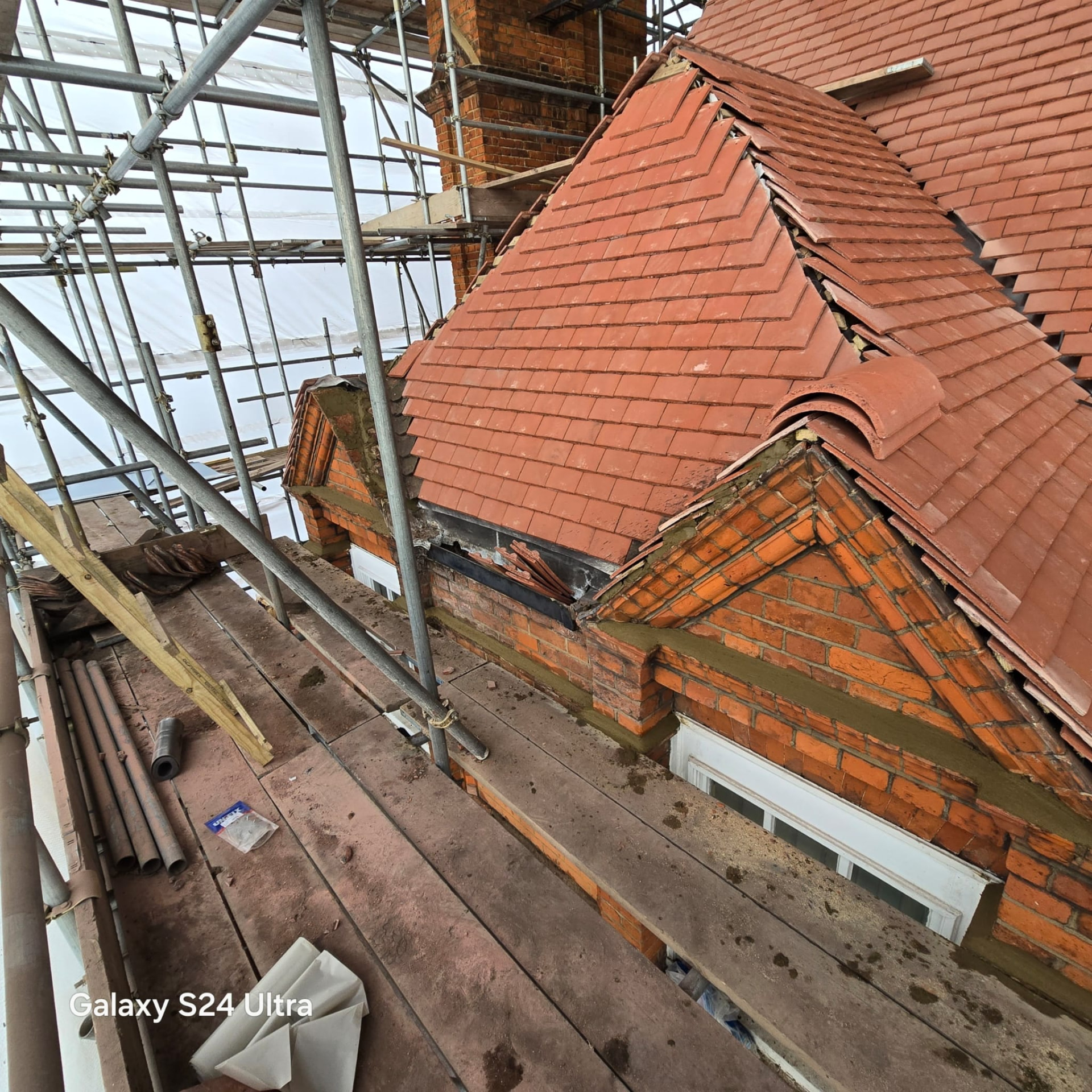 New clay plain tiling completed over the brick dormers and gables with lead soakers in place