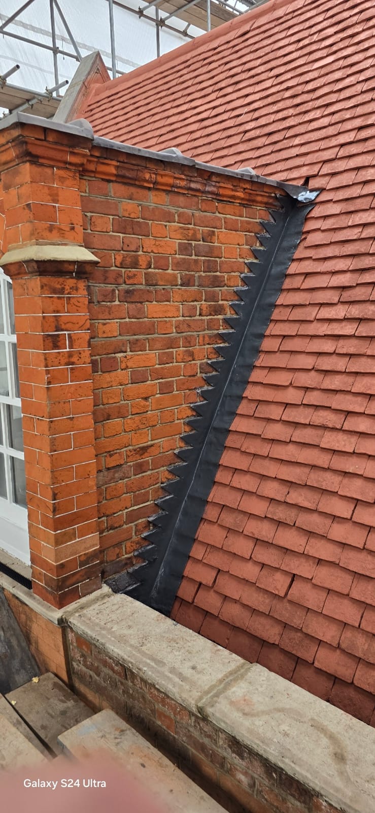 New raking lead flashing and soakers stepped into the brick gable beside the tiled slope