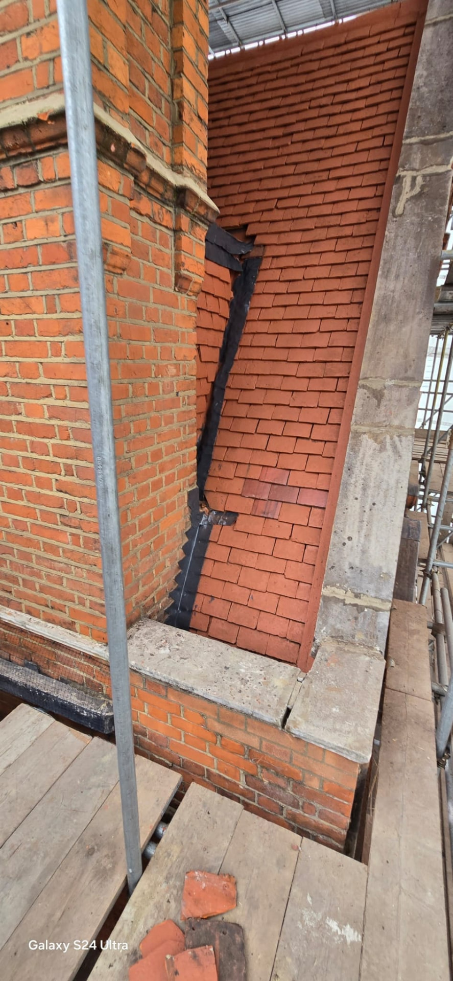 Close detail of lead flashing and tile abutment against original brickwork
