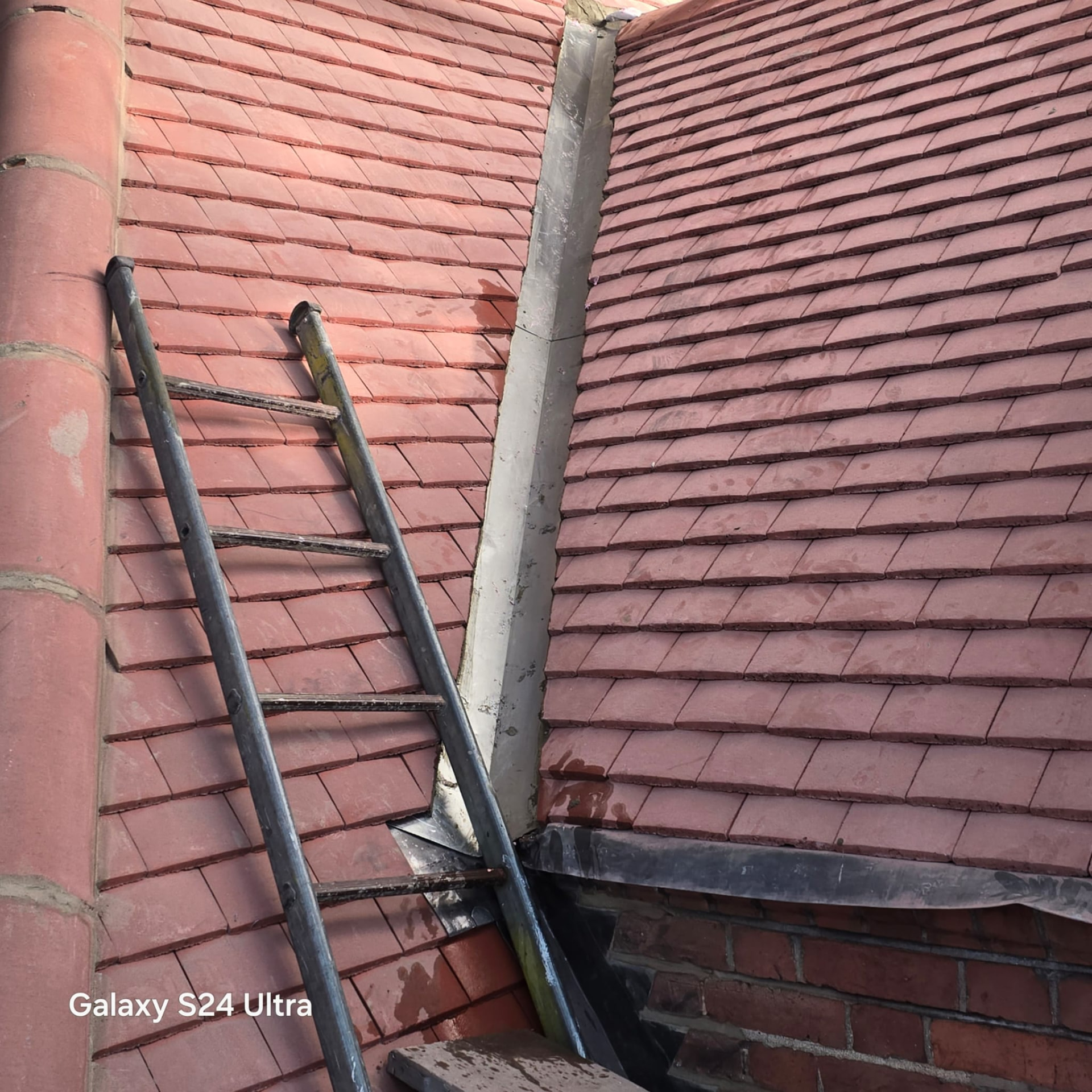 New lead valley dressed between two pitches of clay plain tiling