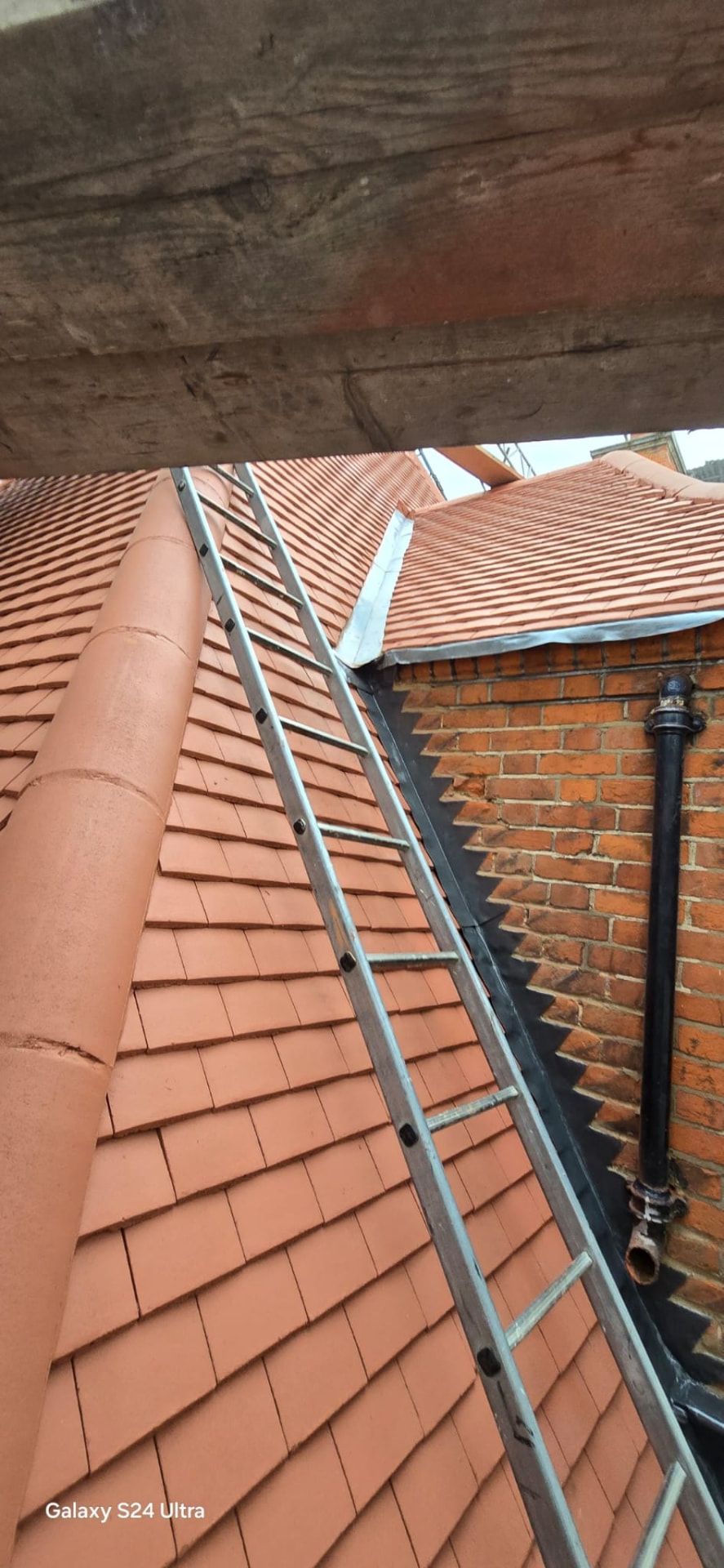 Ladder up the finished clay tiled slope with new lead soakers dressed into the brick abutment